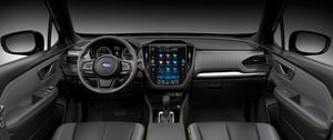 Innenraum eines Subaru Forester mit schwarzem Armaturenbrett, multifunktionalem Lenkrad und großem Touchscreen in der Mittelkonsole
