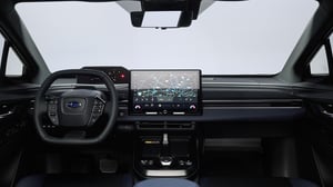 Innenraum eines Subaru Solterra mit Lenkrad, digitalem Kombiinstrument und großem Touchscreen in der Mittelkonsole
