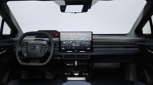 Innenraum eines Subaru Solterra mit Lenkrad, digitalem Kombiinstrument und großem Touchscreen in der Mittelkonsole
