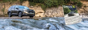Dunkelgrauer Forester steht am Ufer hinter fließendem Wasser vor Felswand und das neue Subaru Drive Magazin ist daneben eingefügt.
