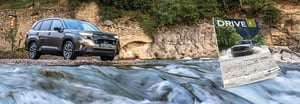Dunkelgrauer Forester steht am Ufer hinter fließendem Wasser vor Felswand und das neue Subaru Drive Magazin ist daneben eingefügt.