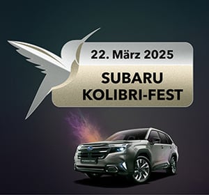 Subaru Kolibri-Fest Badge darunter steht ein silberner Forester in Frontansicht.