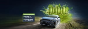 Subaru Solterra fährt auf Straße, dahinter große grüne Zahl '4000€' und Umweltbonus Signet daneben